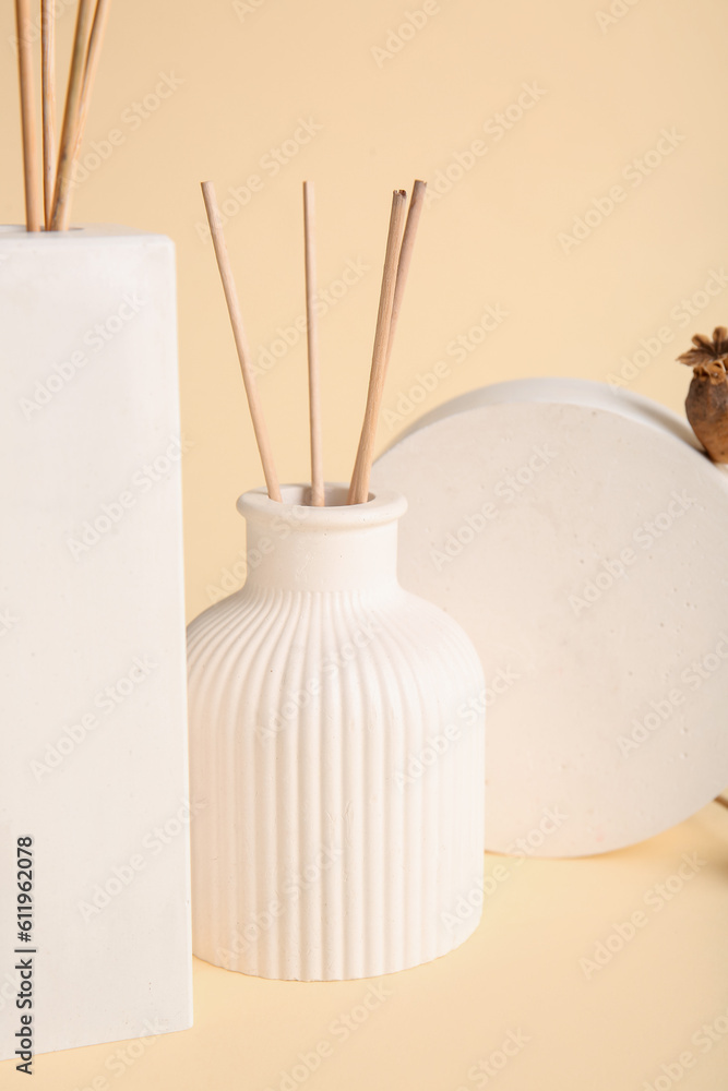 Bottles of reed diffuser on beige background, closeup