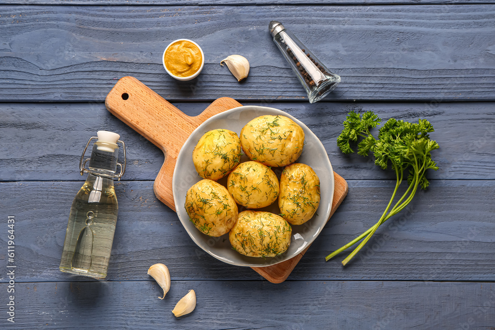 Plate of boiled baby potatoes with dill and parsley on blue wooden background