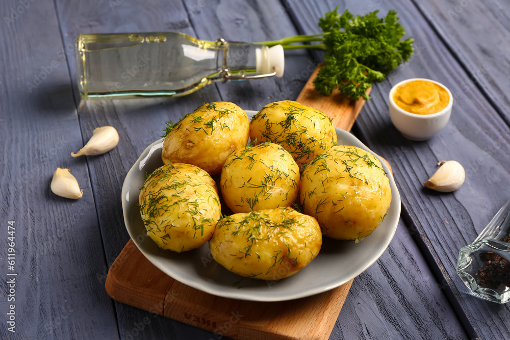 Plate of boiled baby potatoes with dill and parsley on blue wooden background