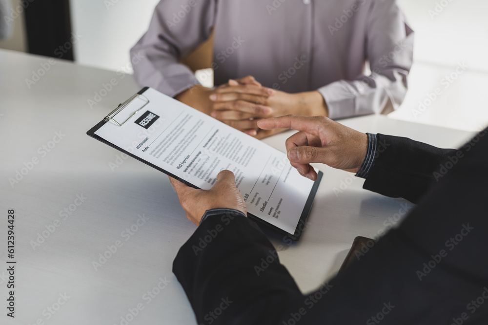 Woman submits an application to the personnel committee. The manager reads the resume and discusses 