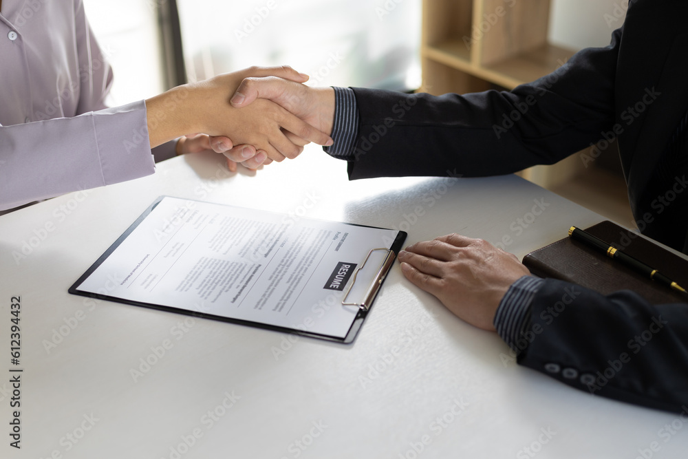 Real estate agents shake hands after reaching an agreement and signing a legal home purchase.