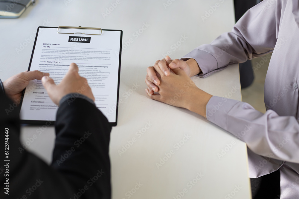 Woman submits an application to the personnel committee. The manager reads the resume and discusses 