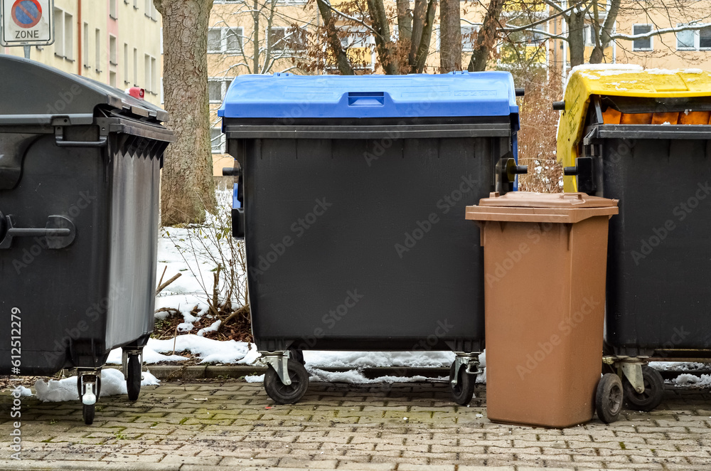 View of garbage containers in city on winter day