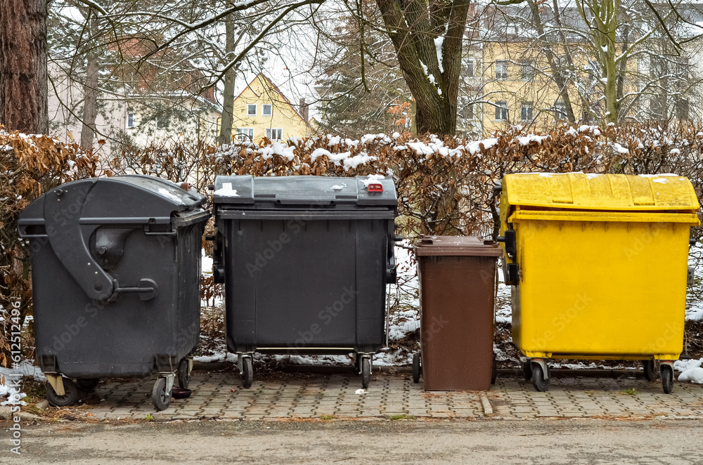 View of garbage containers in city on winter day