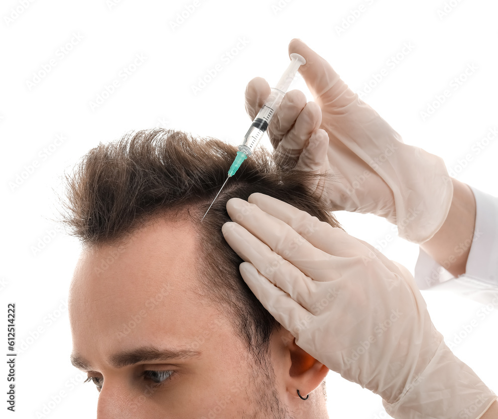 Young man receiving injection for hair growth on white background, closeup