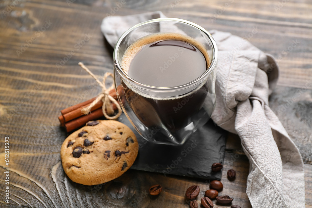 Drink coaster with cup of coffee, cookie and beans on wooden table