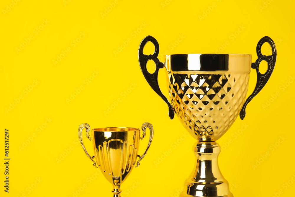 Gold cups on yellow background, closeup