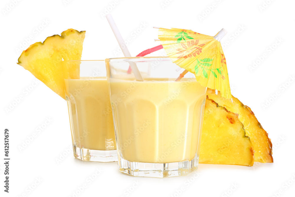 Glass of tasty pineapple smoothie, straw and umbrella on white background