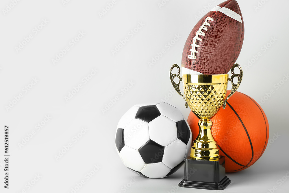 Gold cup with balls on light background