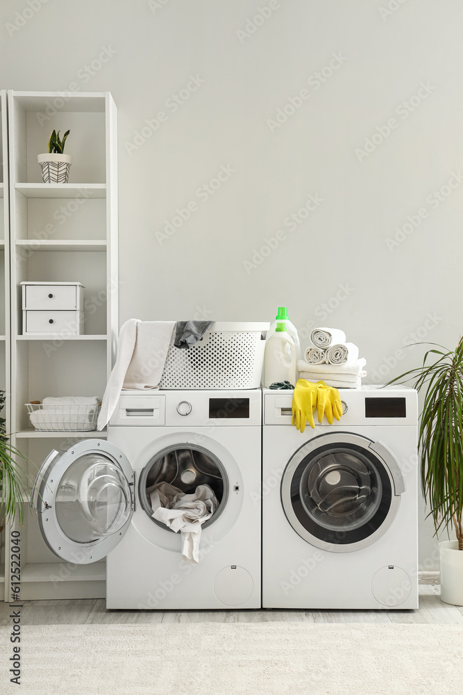 Interior of laundry room with washing machines and cleaning supplies