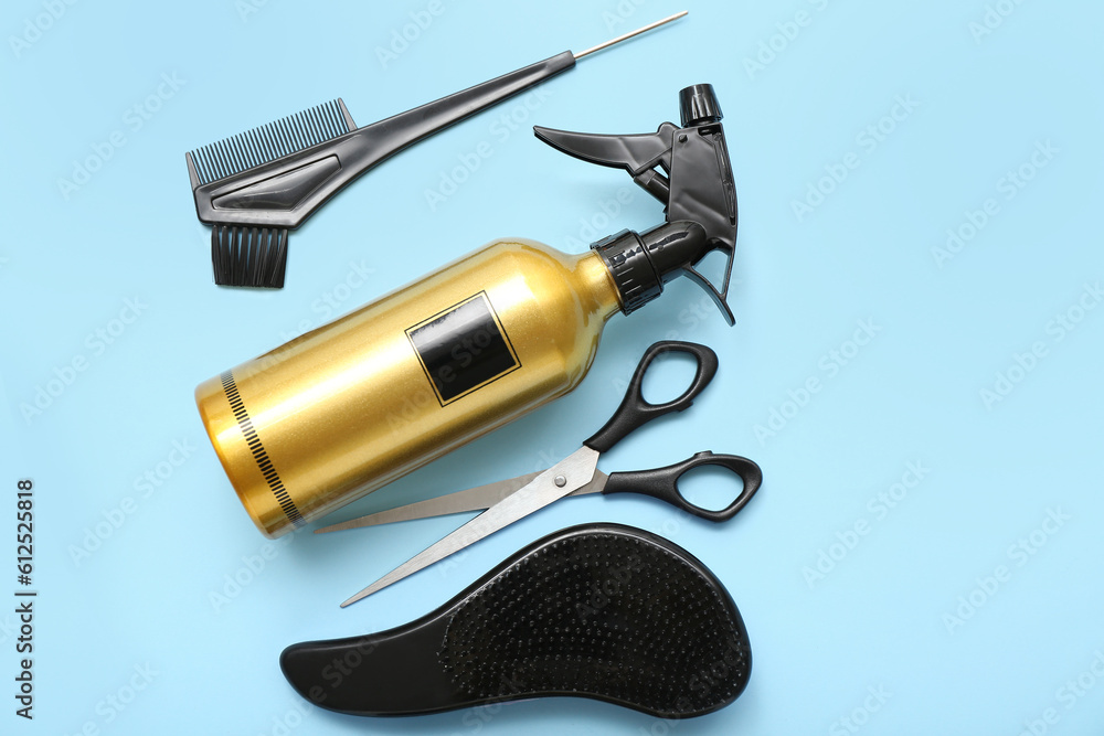 Hair spray with brushes and scissors on blue background