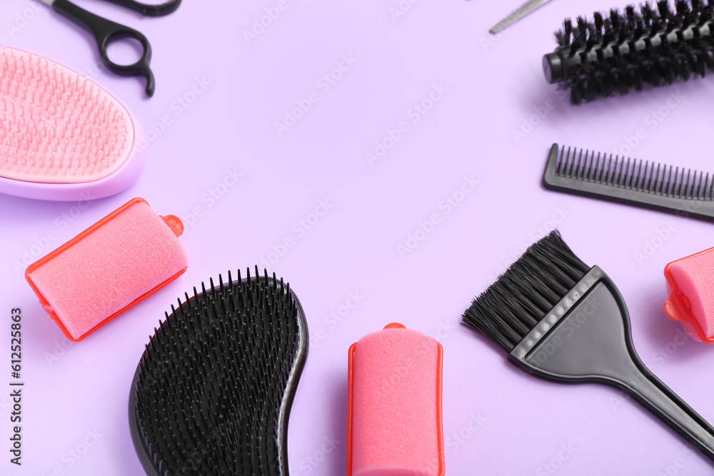 Frame made of hairdressing accessories on lilac background, closeup