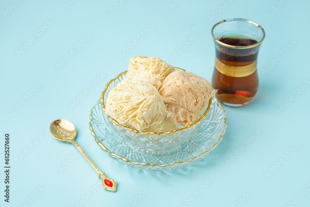 Bowls with tasty Turkish Pismaniye on blue background