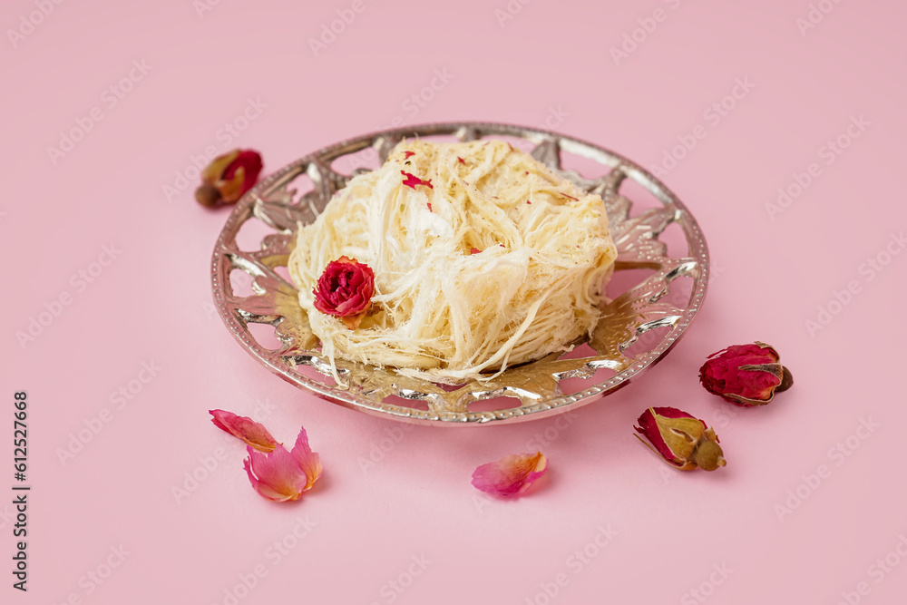 Plate with tasty Turkish Pismaniye on pink background