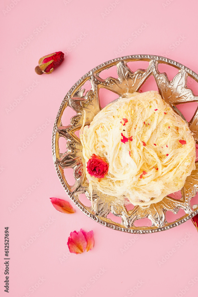 Plate with tasty Turkish Pismaniye on pink background