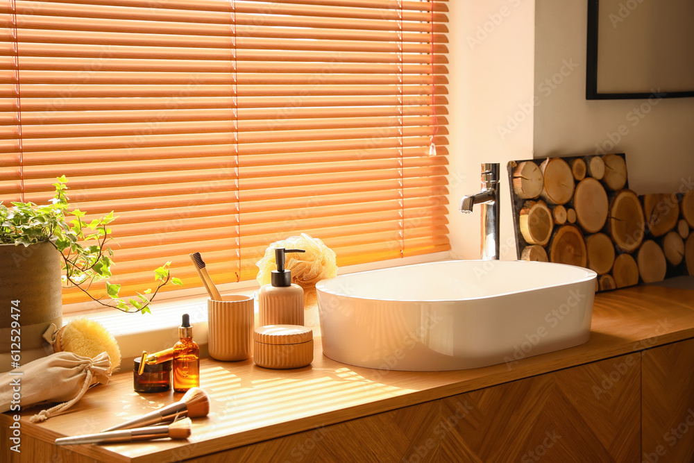 Bath accessories with makeup brushes on table in room