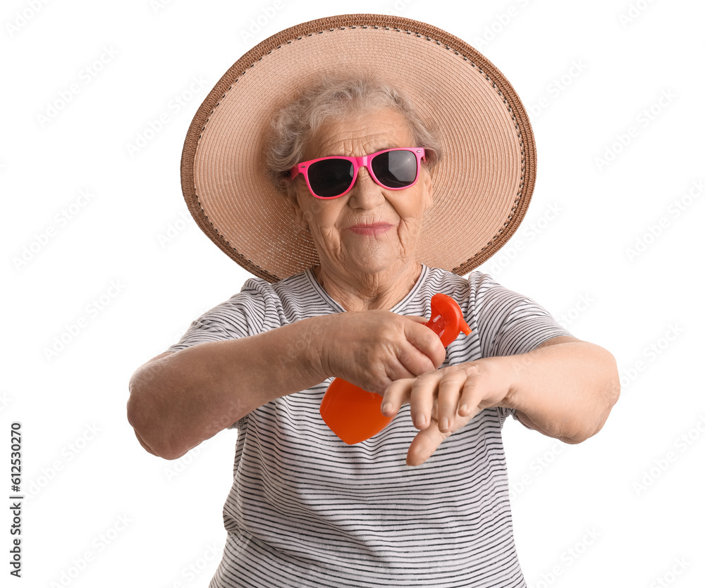 Senior woman applying sunscreen cream on white background