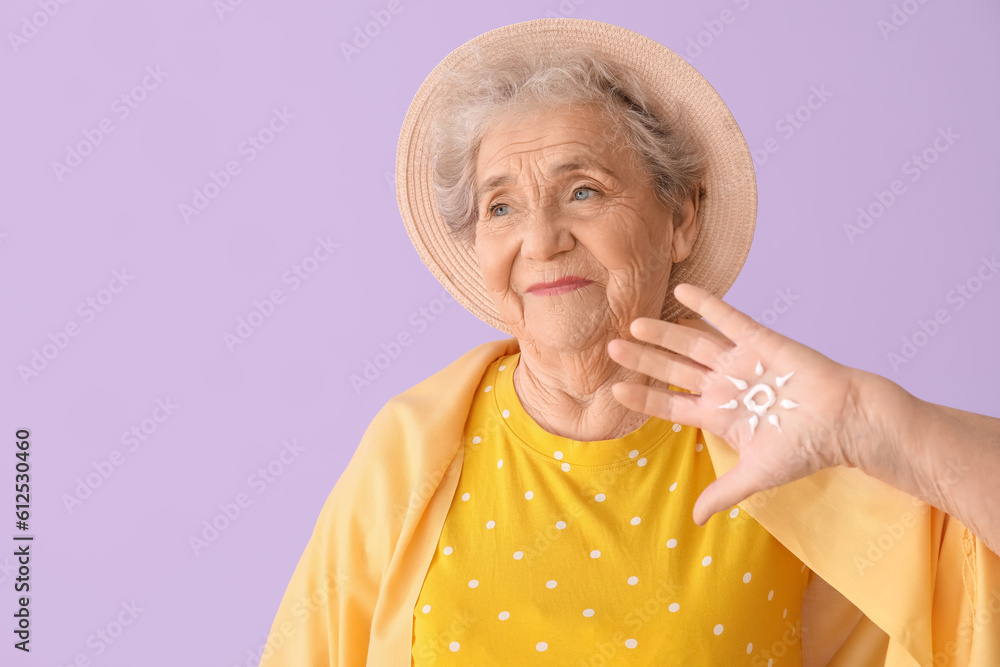 Senior woman with sun made of sunscreen cream on lilac background, closeup