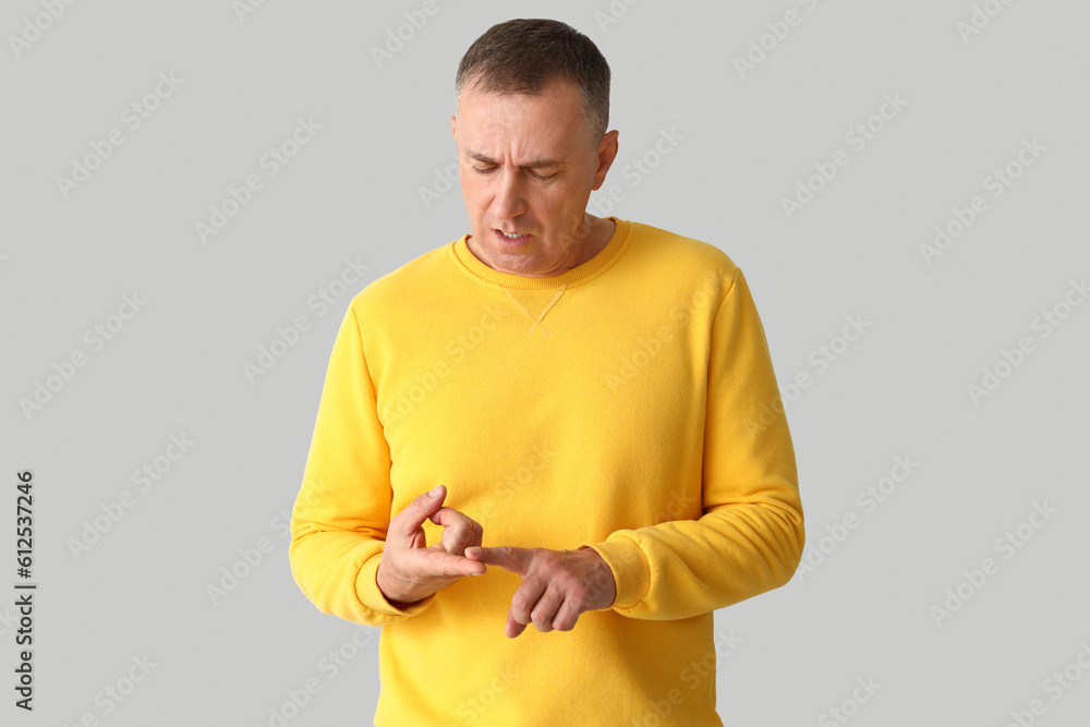 Mature man counting on light background