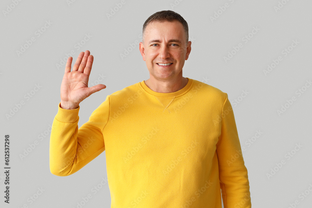 Mature man showing hand on light background