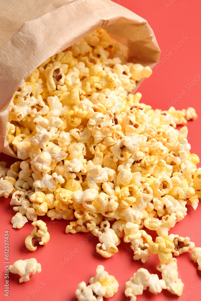 Paper bag with crispy popcorn on red background