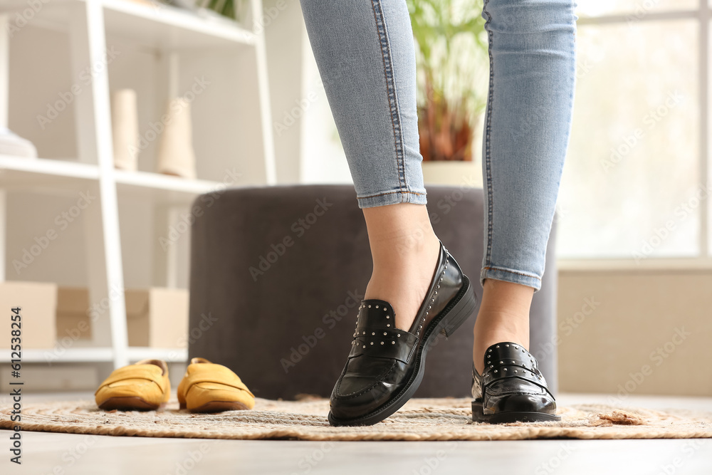 Woman trying on stylish black shoes in boutique, closeup