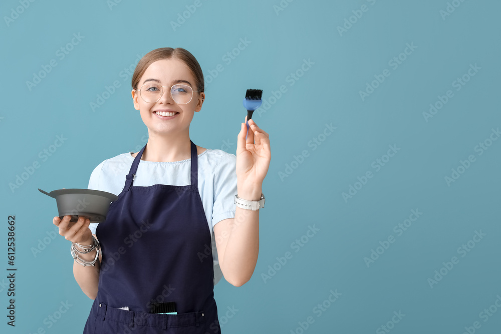 Female hairdresser with bowl and brush for hair dye on blue background