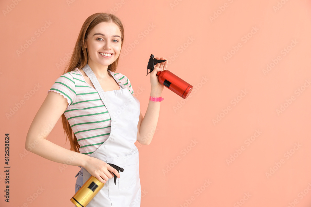 Female hairdresser with sprays on pink background