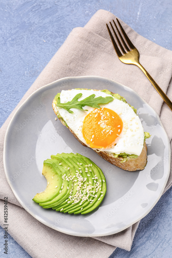 Plate of tasty bruschetta with avocado and egg on grey background