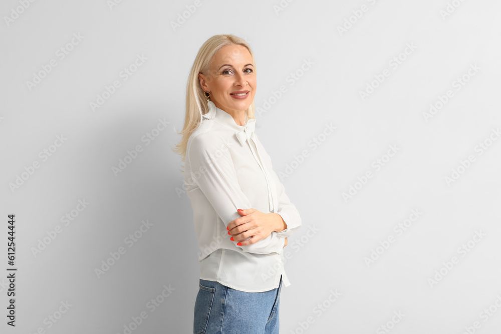 Mature blonde woman on light background