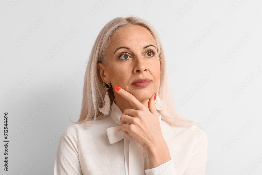 Mature blonde woman on light background, closeup