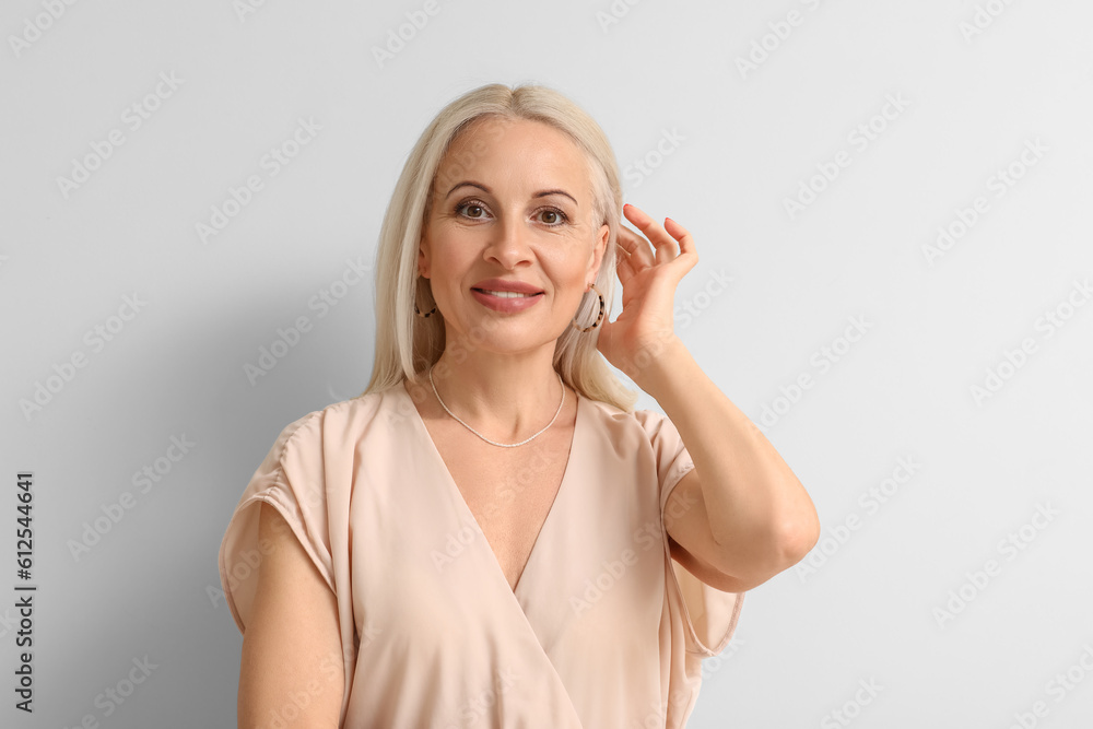 Mature blonde woman on light background