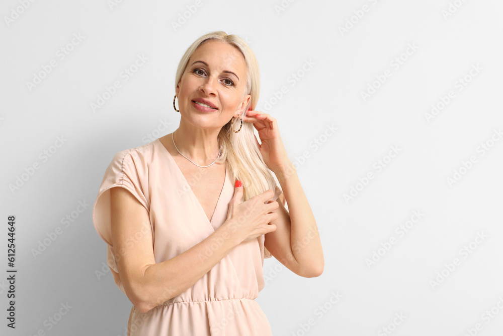 Mature blonde woman on light background