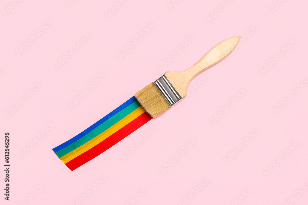 Paint brush with adhesive tapes on pink background