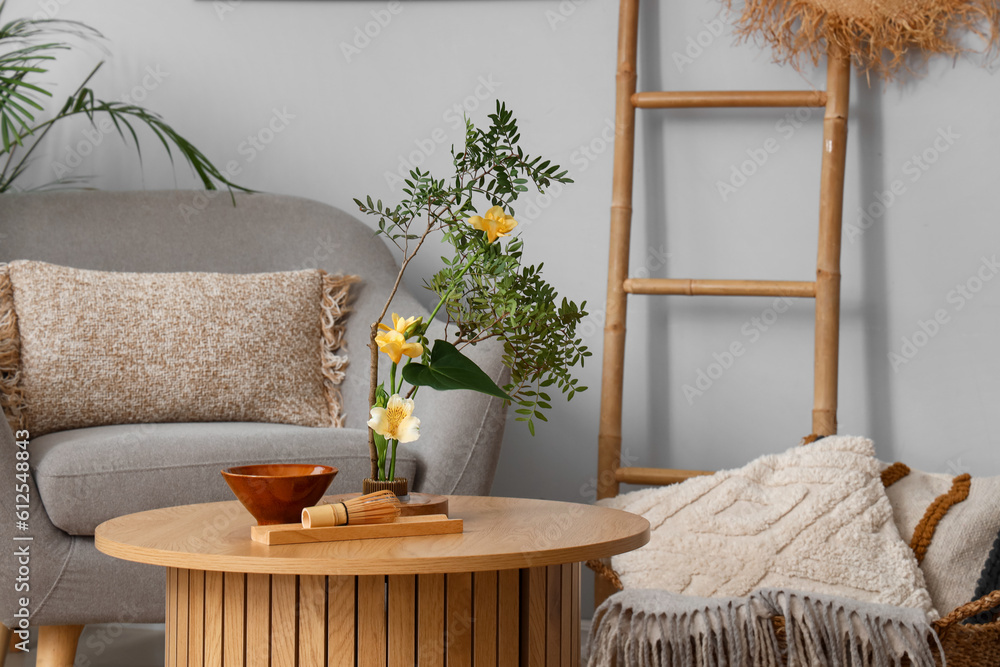 Beautiful ikebana on coffee table in living room