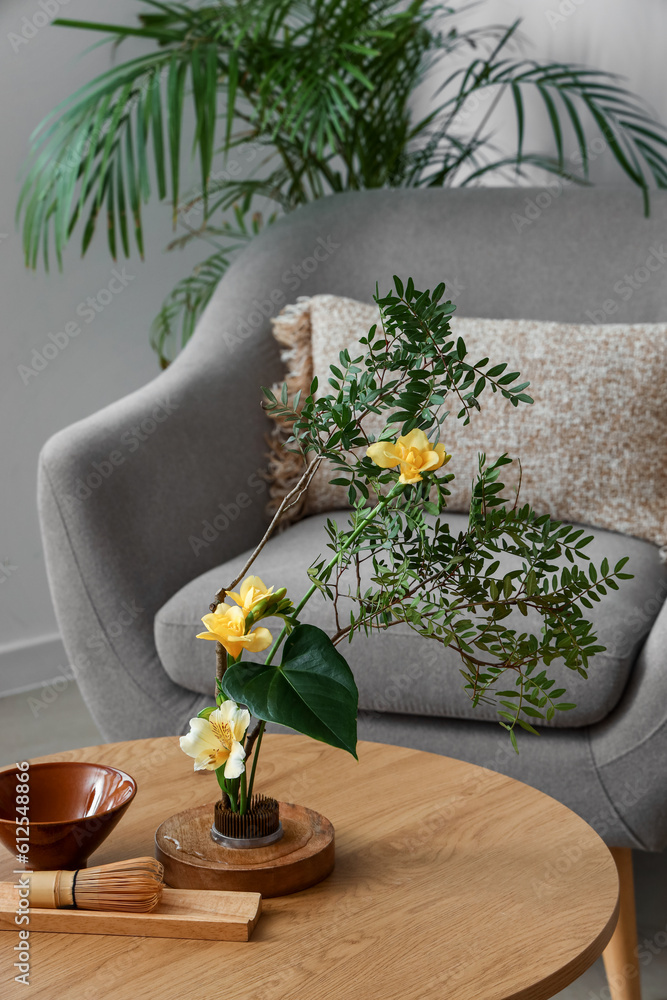 Beautiful ikebana on coffee table in living room