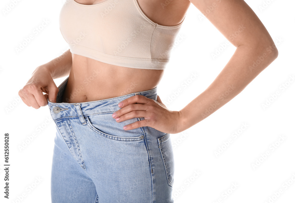 Young woman in loose jeans on white background. Diet concept