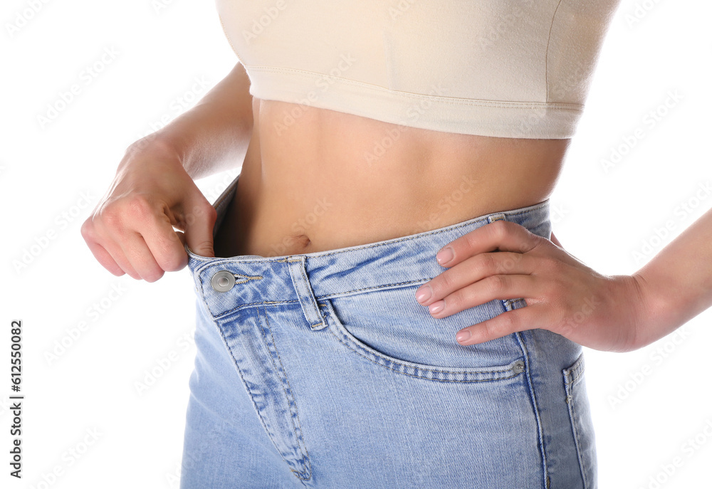 Young woman in loose jeans on white background. Diet concept