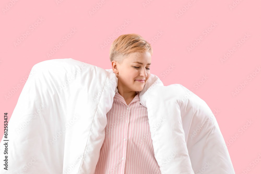 Young woman with soft blanket on pink background