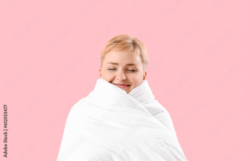 Young woman with soft blanket on pink background, closeup