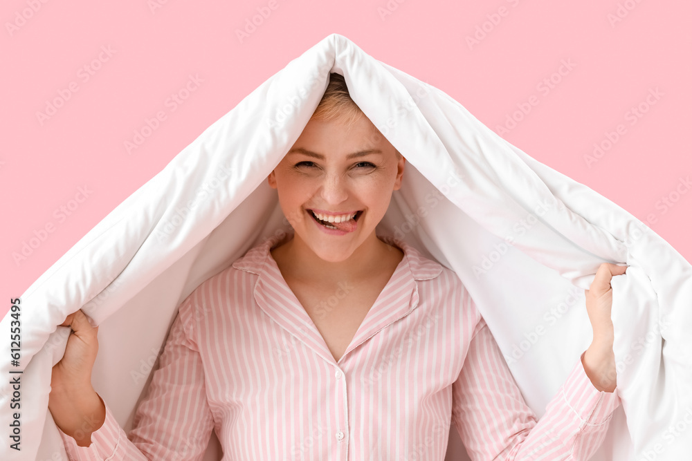 Young woman with soft blanket on pink background, closeup