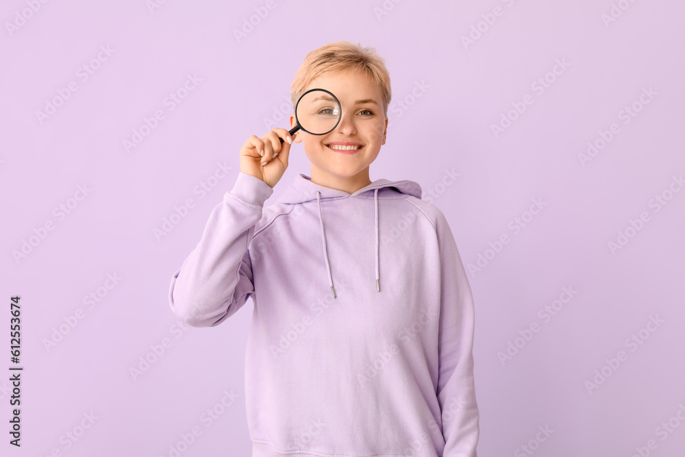 Young woman with magnifier on lilac background