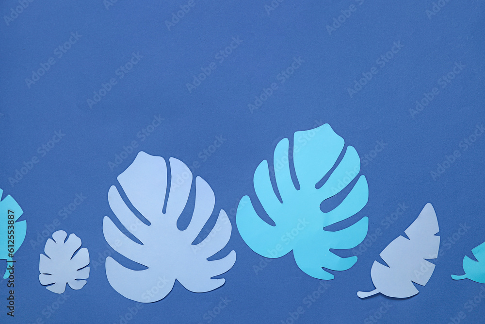 Beautiful origami leaves on blue background