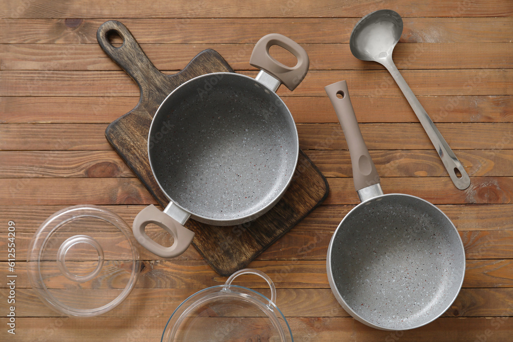 Set of cooking pots on wooden background