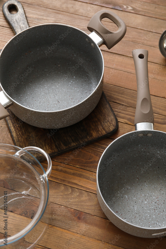 Set of cooking pots on wooden background