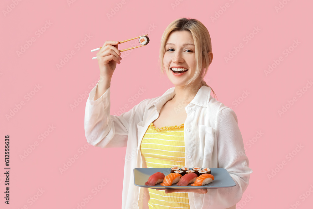 Young woman with sushi on pink background