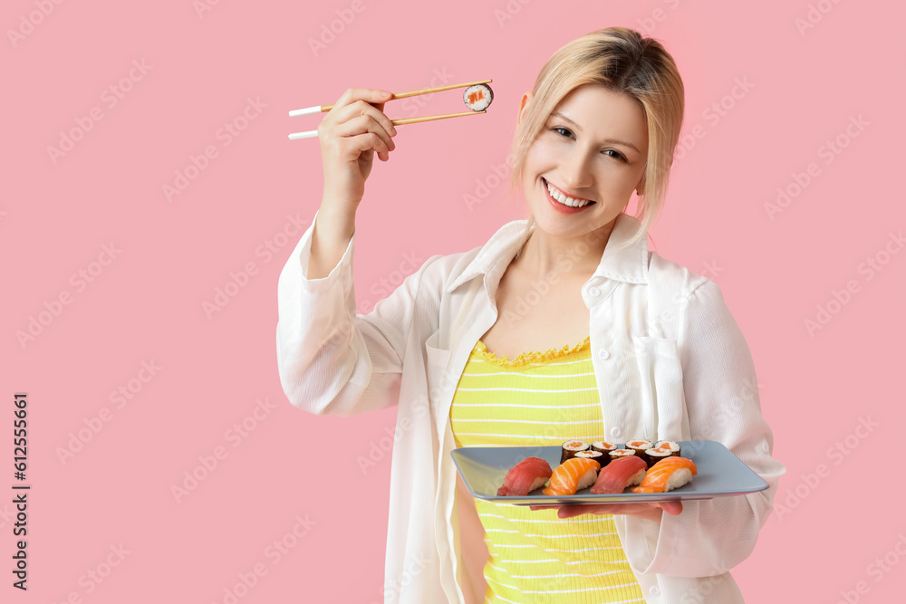 Young woman with sushi on pink background