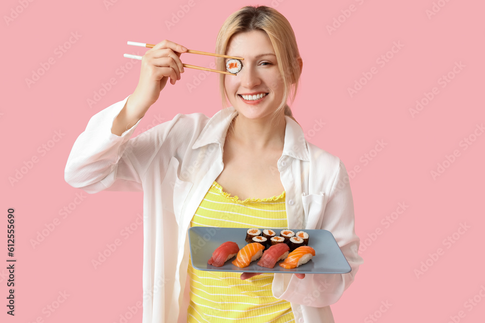 Young woman with sushi on pink background