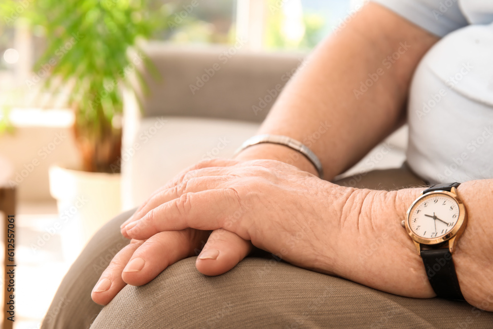 Senior woman sitting on sofa at home, closeup