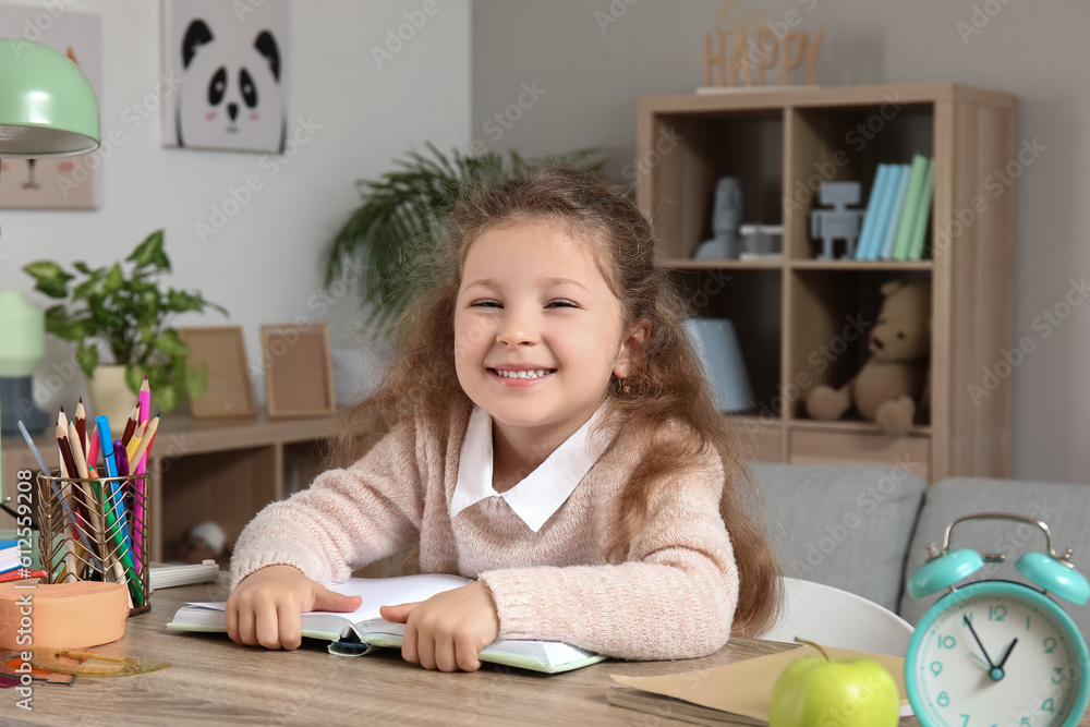 Cute little girl reading book at home